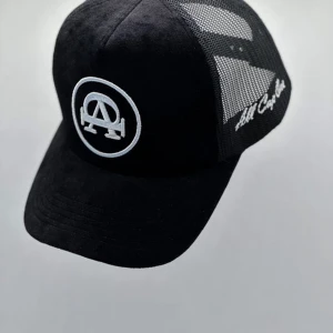 All Cap One  - Snygg svart keps från All Cap One med broderad logga framtill. Kepsen har ett nätmaterial på sidorna och justerbar passform. Perfekt för en avslappnad stil.
