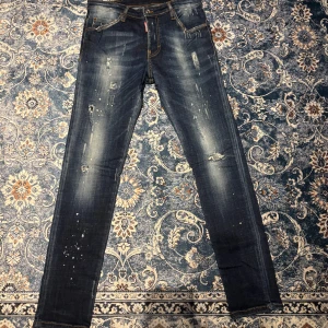 Blå jeans från DSQUARED2 - Snygga blå jeans från DSQUARED2 med slitna detaljer och en cool tvätt. De har en klassisk femficksdesign och en knappgylf. Perfekta för en trendig look.