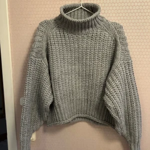 Grå stickad polotröja från H&M - Säljer en grå stickad oversized polotröja från H&M. Tröjan har en hög krage och långa ärmar, Perfekt för höst och vinter!
