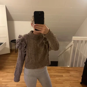 Stickad tröja med volang - Säljer denna superfina stickade tröja med volangdetaljer på ärmarna. 