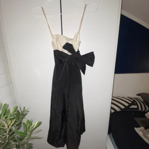 Svart och vit klänning från Zara Basic - Elegant svart och vit klänning från Zara Basic med smala axelband och en stor dekorativ rosett framtill. 🎀Klänningen har en stilren men elegant design med en kontrasterande färgblockseffekt. Perfekt för en chic look till en middag eller liknande sammanhang. 🥰🥂🥂