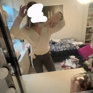 Vit omlottopp från Even&Odd - Säljer en stilren vit omlottopp från Even&Odd. Toppen har långa ärmar och knytning i sidan, vilket ger en snygg passform. Perfekt för en chic och avslappnad look. Använd en gång.