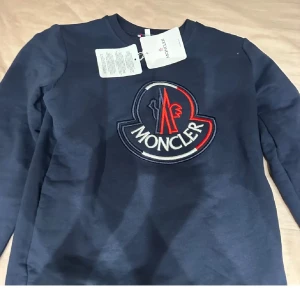 Mörkblå tröja från Moncler - Tjena! Tröjan är kOPl@ Nu säljer jag min snygga  mörkblå tröja från Moncler med stort broderat logotypmärke. Skick 10/10, passar 158-165. Hör av dig vid minsta fundering eller prisförslag! Mvh-Filip 