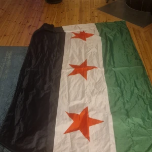 Flagga med tre röda stjärnor - Flagga med tre röda stjärnor på en bakgrund av grönt, vitt och svart. Perfekt för att hänga upp i hemmet eller använda vid evenemang.