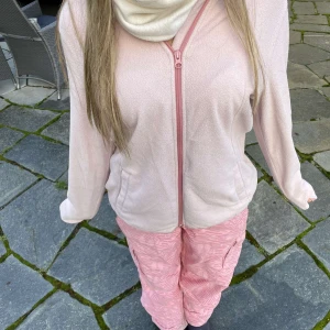 Rosa cargobyxor med mönster - Snygga rosa cargobyxor med ett subtilt mönster. Byxorna har flera praktiska fickor och en loose passform som ger en avslappnad stil. Perfekta för sportlovet när man går på afterski