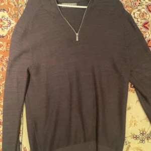 Mörkgrå tröja med dragkedja från Primark - Säljer en stilren mörkgrå tröja från Primark med dragkedja vid halsen. Tröjan har långa ärmar och är perfekt för kyligare dagar. Enkel och snygg design som passar till det mesta.