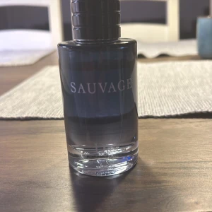 Dior sauvage edt 80ml - Säljer en elegant och maskulin parfym från Dior, Sauvage. Flaskan är stilren med en mörkblå ton och silverdetaljer. Perfekt för den som vill ha en fräsch och kraftfull doft. Ca 80ml kvar ( dior sauvage edt)