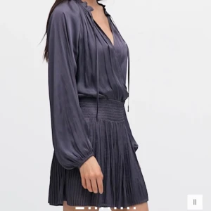 Mörkgrå klänning med knytband - Elegant mörkgrå klänning med långa ärmar och knytband vid halsen. Helt ny med prislapp. 