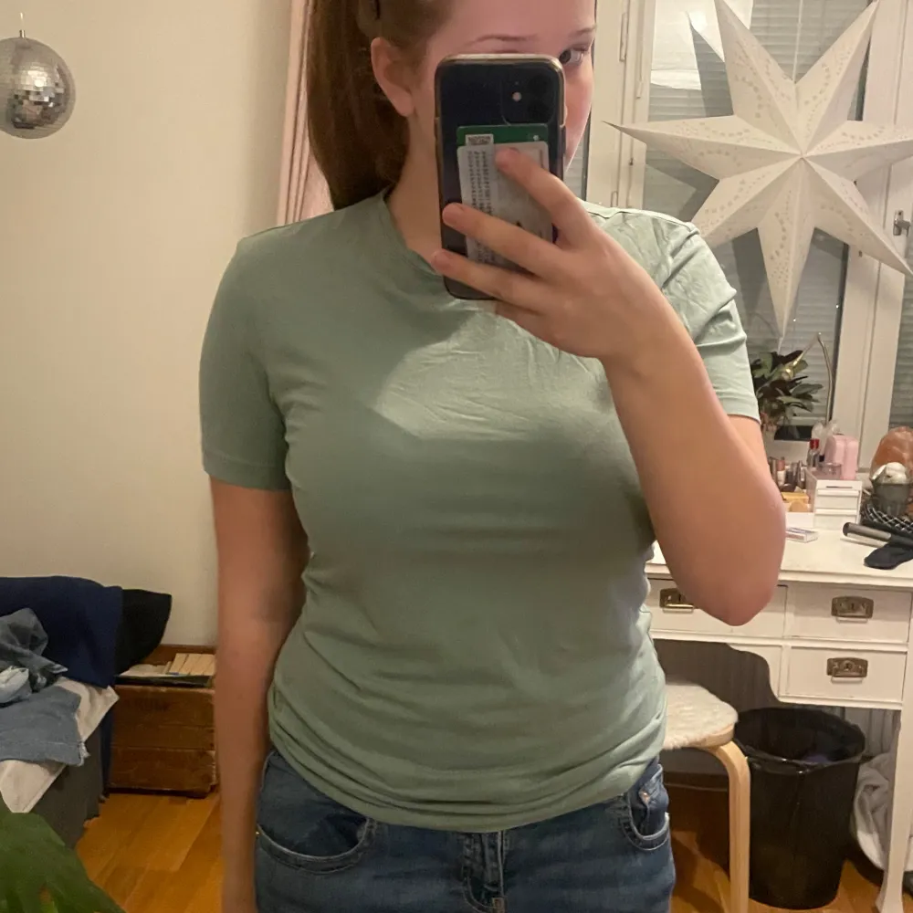 Säljer en grön t-shirt från H&M i slim fit. Den har en enkel design med korta ärmar och rund hals. Perfekt för en avslappnad stil. Storlek är S men passar även M.. T-paidat.