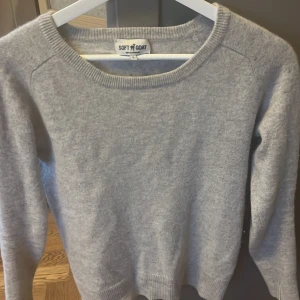 Grå kashmirtröja från Soft Goat - Mysig grå kashmirtröja från Soft Goat med rund hals och långa ärmar. Perfekt för kyliga dagar och ger en lyxig känsla. Tröjan har en enkel och stilren design som passar till det mesta.