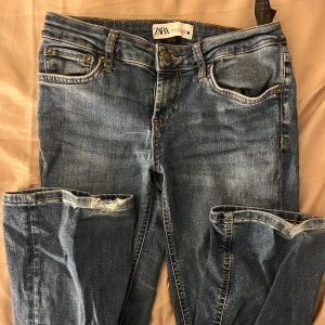 Blå jeans från Zara - Snygga lågmidjade bootcut jeans från zara. Materialet är mer stretchigt. Kommer ej till användning och är i ett använt skick, slitna vid hälarna.