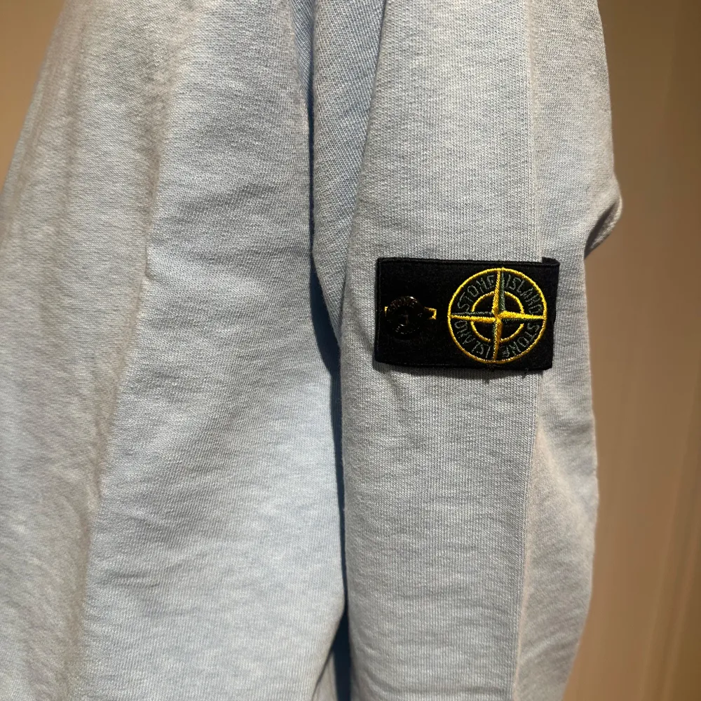 Säljer en snygg ljusblå tröja från Stone Island med deras snygga märke på ärmen. Inköpt på NK i Stockholm för 2149kr. Storleken är 14y (år)/164 cm.m. Den är långärmad och har ribbade muddar vid ärmslut och nederkant. Säljes då det blev en julklapp som var lite för stor. Helt ny och oanvänd med lappar kvar. Skriv vid frågor 🤍. Neuletakit & Villapaidat.