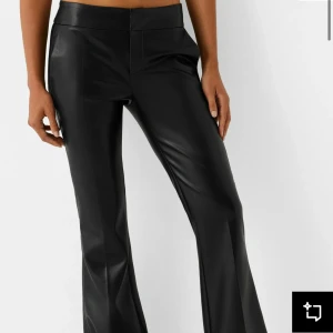 Svarta lågmidjade bootcut läderbyxor  - Snygga svarta skinnbyxor med bootcut-stil. Perfekta för en trendig look med låg  midja och en smickrande passform. Byxorna har en slät yta och ger en cool vibe.