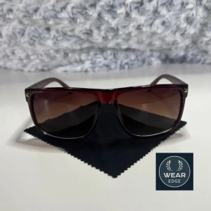 Bruna solglasögon från Wear Edge - Snygga bruna solglasögon från Wear Edge med en klassisk rektangulär form. Perfekta för soliga dagar och ger en stilren look. Kommer med ett praktiskt fodral. Sänkt pris nu!!!!