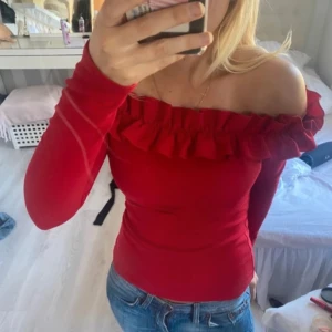 Röd offshoulder topp från NLY Trend - Säljer en snygg röd offshoulder topp från NLY Trend. Toppen har långa ärmar och en volangdetalj runt halsringningen. Helt ny och oanvänd. Köpt från en annan säljare men tyvärr passade den inte mig!         (Ej min bild, utan tagen från tidigare säljare!!) 