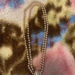 Pärlhalsband med silverdetalj - Elegant pärlhalsband med dubbla rader av vita pärlor och en vacker silverdetalj i mitten. Perfekt för att ge en klassisk touch till din outfit. Priset kan diskuteras vid snabb affär 