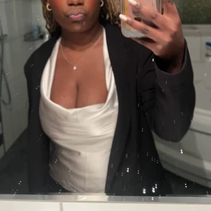 Gildig sidenlinne - Elegant vit sidenlinne med smala axelband och knytning i ryggen. Perfekt för en stilren och sofistikerad look.