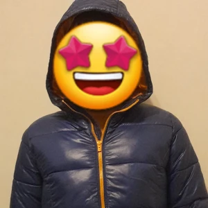 Blå pufferjacka med orange detaljer - Snygg blå pufferjacka med kontrasterande orange dragkedja och foder. Perfekt för kyliga dagar med sin quiltade design och långa ärmar. Jackan har en praktisk huva för extra skydd mot väder och vind. Inga defekter och passar dig runt 160cm perfekt. Orange i insidan.