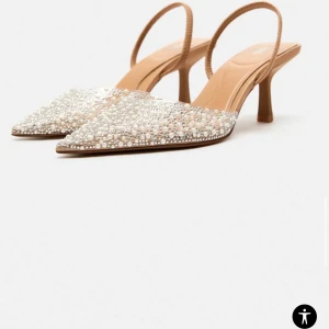Glittriga pumps med pärlor - Eleganta pumps med spetsig tå och klack. Skorna är dekorerade med glittriga pärlor och har en beige rem. Perfekta för en festlig look. Enbart använt en gång så definitivt i nyskick 