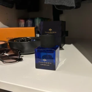 Thameen Carved Oud Parfym - Elegant parfym från Thameen i en stilren blå flaska med svart lock. Doften Carved Oud ger en lyxig och sofistikerad känsla. Perfekt för den som söker en unik och minnesvärd doftupplevelse.