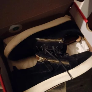 Mörkblå guissepie - Snygga svarta sneakers med dragkedja på sidan och snörning. Perfekta för en stilren look.