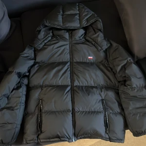 Levis vinterjacka - Säljer en levis jacka med borttagbar luva! Jackan är felfri förutom att snöret man hänger jackan med har gått sönder! Jackan är bland de varmaste jackor jag haft men känner att den är för stor o vill testa något nytt! Jackan kostar 2500 ny.