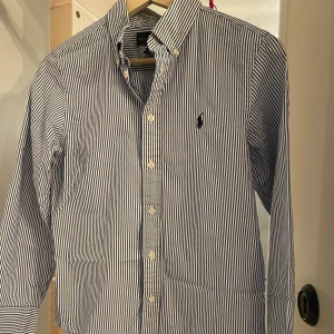Ralph lauren skjorta randig - Snygg blå- och vitrandig skjorta från Ralph Lauren i nytt skick, storleken är ”14” 