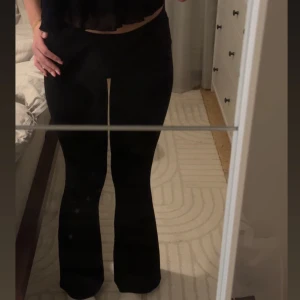 Svarta bootcut byxor från Gina - Snygga och sköna svarta bootcut byxor med låg/medelhög midja från Ginatricot. Perfekta för en stilren look och passar till många olika outfits. Materialet är stretchigt!
