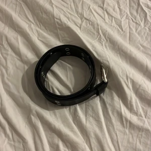 Svart bälte med nitar - Snyggt svart bälte med silverfärgade nitar längs hela längden. Perfekt för att ge en edgy touch till din outfit. Justerbart spänne i silver. Skulle ge till en kompis men de blev aldrig av så de har bara legat kvar och inte blivit använd💞Skriv vid intresse 