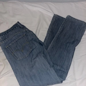 Levi's 511 jeans i blå denim - Säljer ett par klassiska Levi's 511 jeans i blå denim. De har en slim passform och är midwaist. Perfekta för en stilren look med fem fickor och dragkedja.