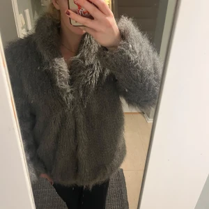 Grå pälsjacka - Fluffig och stilren grå pälsjacka . Perfekt för att hålla sig varm. Pris kan diskuteras 