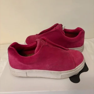 Rosa sneakers från Eytys - Snygga rosa sneakers från Eytys i mocka med en stilren design. Skorna har en vit sula och saknar snörning för en smidig look. 