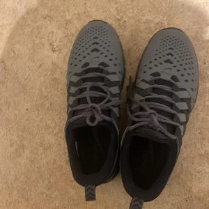 Grå Nike sneakers - Snygga grå Nike sneakers med svart sula och snörning. Perfekta för en sportig look med stilren design och bekväm passform.