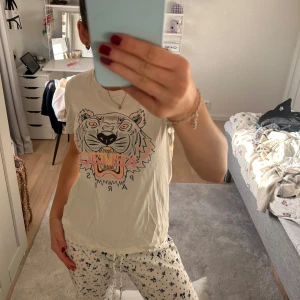 Beige t-shirt med tigertryck - Snygg beige t-shirt med ett coolt tigertryck i svart och orange. Perfekt för en avslappnad stil. Kortärmad och i mjukt material.