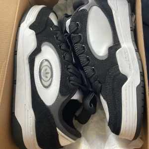 Svartvita sneakers från Adidas - Säljer ett par svartvita Adidas sneakers med en stilren design. Skorna har en kombination av syntetmaterial och mocka, med snörning framtill. Perfekta för en sportig look. Skorna är köpta för 1500 säljer för 1200 dem e använda en gång pris kan diskuteras 