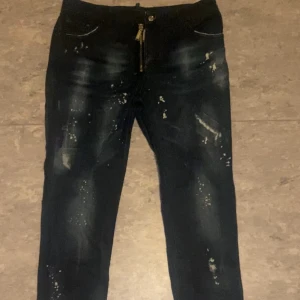 Mörkblå jeans med dragkedja från Dsquared2 - Snygga mörkblå jeans från Dsquared2 med unika slitningar och en cool dragkedja framtill. Perfekta för en trendig look. Tillverkade i Italien.