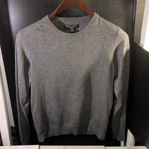 Grå tröja från Amisu - Säljer en stilren grå tröja från Amisu. Tröjan är långärmad och har en klassisk rund halsringning. Perfekt för en enkel och snygg look. Tillverkad i ett mjukt material som känns skönt mot huden. Hör av er vid minsta fundering🙌