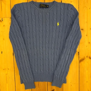 Blå Ralph Lauren kabelstickad tröja  - 🌟extremt bra skick och toppen kvalité, enbart använd en gång  📬Jag postar 0-1 dagar efter köp 🐑100% bomull 📏storlek XS 📐37cm axelbredd, 54cm full längd, 55cm ärmlängd ☺️skriv om du har några funderingar eller vill ha fler bilder 