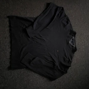 Grå tröja från Tommy Hilfiger - Säljer en stilren svart tröja från Tommy Hilfiger i Pima Cotton Cashmere. Tröjan har långa ärmar och en klassisk design med ribbade muddar vid ärmslut och nederkant. Perfekt för en elegant och bekväm look.