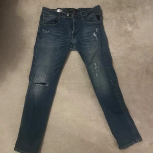Blå jeans från Replay - Snygga blå jeans från Replay med slitna detaljer. 