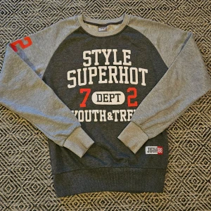 Grå sweatshirt från Bolf - Säljer en grå sweatshirt från Bolf med tryck 'Style Superhot'. Tröjan har långa ärmar och rund halsringning. Perfekt för en avslappnad stil. Lite slitet på märket annars fin.