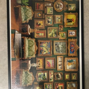 Pussel med konstmotiv - Ett färgglatt pussel som föreställer en vägg täckt av olika konstverk i guldramar. Motiven inkluderar både klassiska och moderna konststilar. Perfekt för konstälskare som vill ha en utmaning och en vacker dekoration när det är klart.