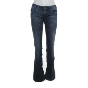 Lågmidjade bootcut jeans från Benetton - Snygga blå bootcut jeans med låg midja från Benetton med en klassisk femficksdesign. I en mörkare tvätt och storlek 27💗innerbenslängden är 76 cm och midjemåttet 74. Byxorna är fransiga längst ner! 