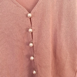 Rosa  kofta med pärlknappar - Säljer en söt rosa ribbad kofta med pärlknappar framtill. Den har långa ärmar och en croppad design som ger en trendig look. Perfekt för att lägga till en feminin touch till din outfit.  💖
