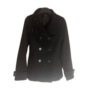 Svart kappa - Snygg svart kappa från H&M med dubbelknäppning och stilrena knappar. Jackan har långa ärmar och en klassisk krage. Perfekt för kyligare dagar och ger en elegant look. Inga defekter!