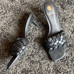 Svarta flätade sandaler från La Strada - Snygga svarta sandaler från La Strada med flätad rem och låg klack. Perfekta för en stilren look. Sandalerna har en fyrkantig tå och är tillverkade i syntetmaterial. Aldrig använda 