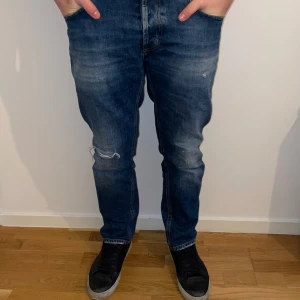 Blå jeans från Dondup - Snygga blå jeans från Dondup med en klassisk femficksdesign. De har en lätt slitning på knäet och en knappgylf. Perfekta för en avslappnad stil. Brighton Carrot Fit på jeansen!