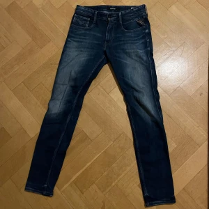 Replay Anbass Jeans - Mörkblå Replay jeans i storleken, W31/L32. Använda väl med schyssta slitningar på låren.