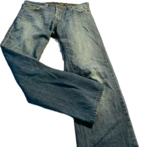 Blå jeans från Vanguard - W30/L34 Snygga blå (lite grå ton) jeans från Vanguard med klassisk femficksdesign. De har en rak/lite utsvängd passform och är tillverkade i slitstarkt denim men skulle säga att de är mjukare än vanliga jeans i tyget (inte det här hårda stela). Perfekta för en avslappnad stil.
