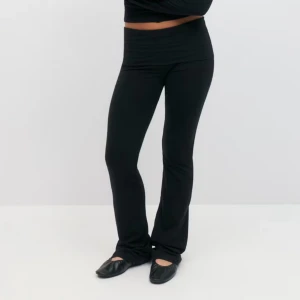 gina young yogapants - Snygga svarta yogapants från Gina Young med en tight passform och bootcut-stil. De är lågmidjade och perfekta för en stilren look. Byxorna är tillverkade i ett mjukt och stretchigt material som ger en bekväm känsla hela dagen.